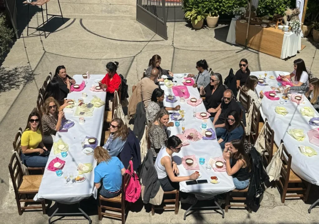 Vista aèria d'un dinar de grup en taules llargues a l'aire lliure durant un esdeveniment corporatiu